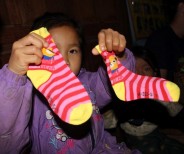 A young girl from the village delighted with her new socks that we brought as a gift to all the children